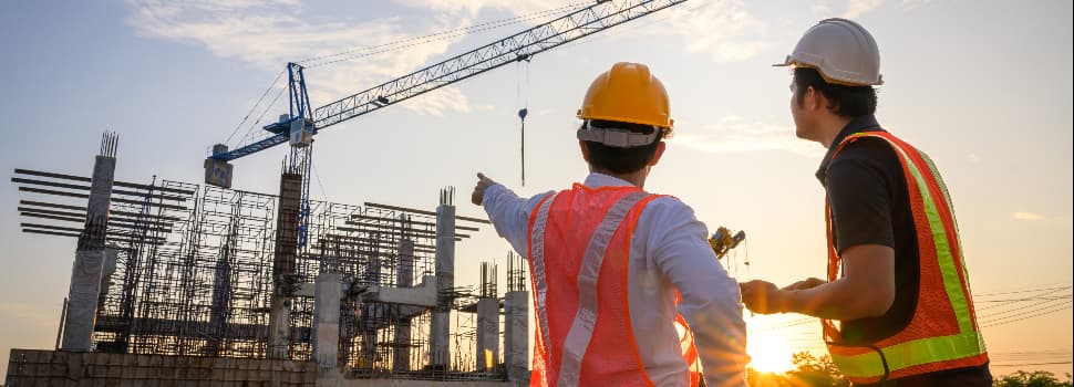 two-workers-talking-and-pointing-at-a-construction-site