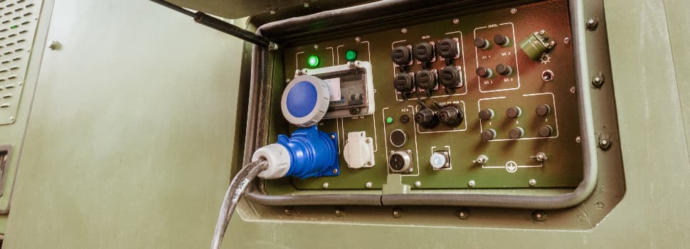 Military-grade power distribution box with industrial electrical connectors, switches and control panel components installed inside a protective enclosure