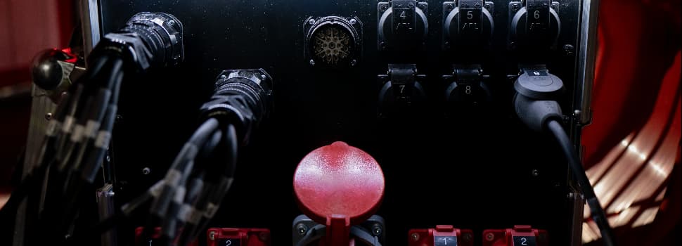 Close-up of an industrial power distribution unit with multiple numbered sockets and connected cables.